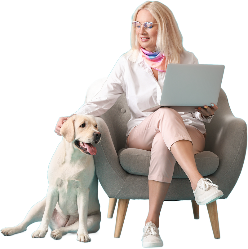 woman with a laptop on a chair stroking a dog